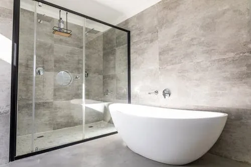 Modern bathroom with large-format wall and floor tile and a freestanding tub