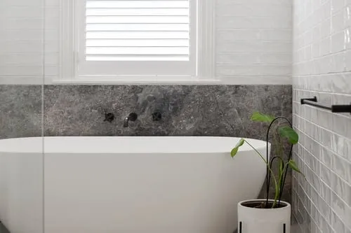 Finished modern bathroom with tiled walls, floor and freestanding tub